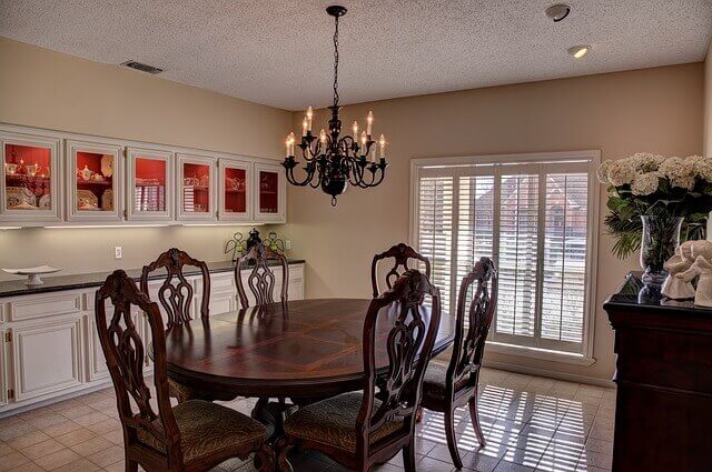 round dining table under a hanging chandelier